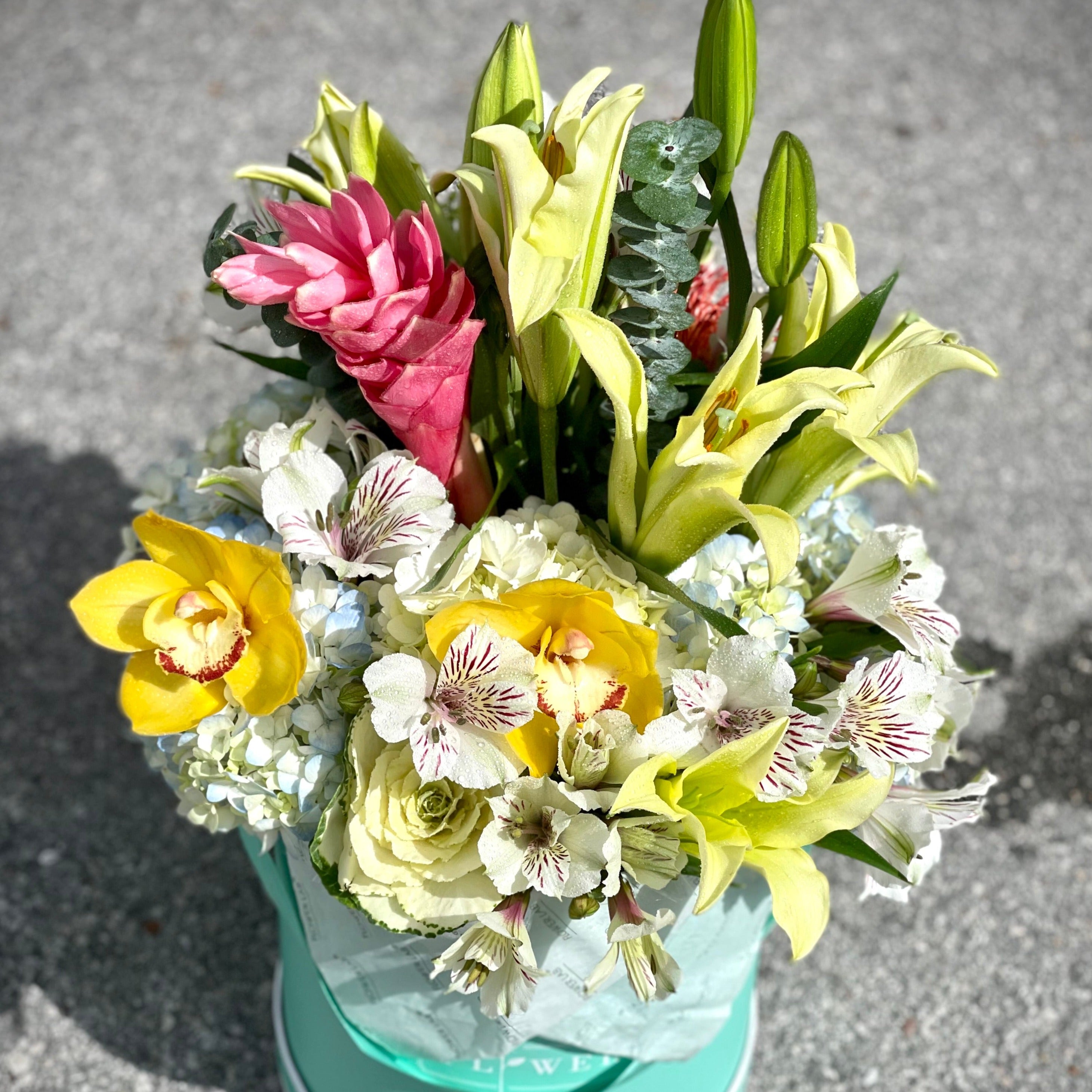Tropicana arrangement in a large box with lilies, hydrangeas, ginger, and orchids