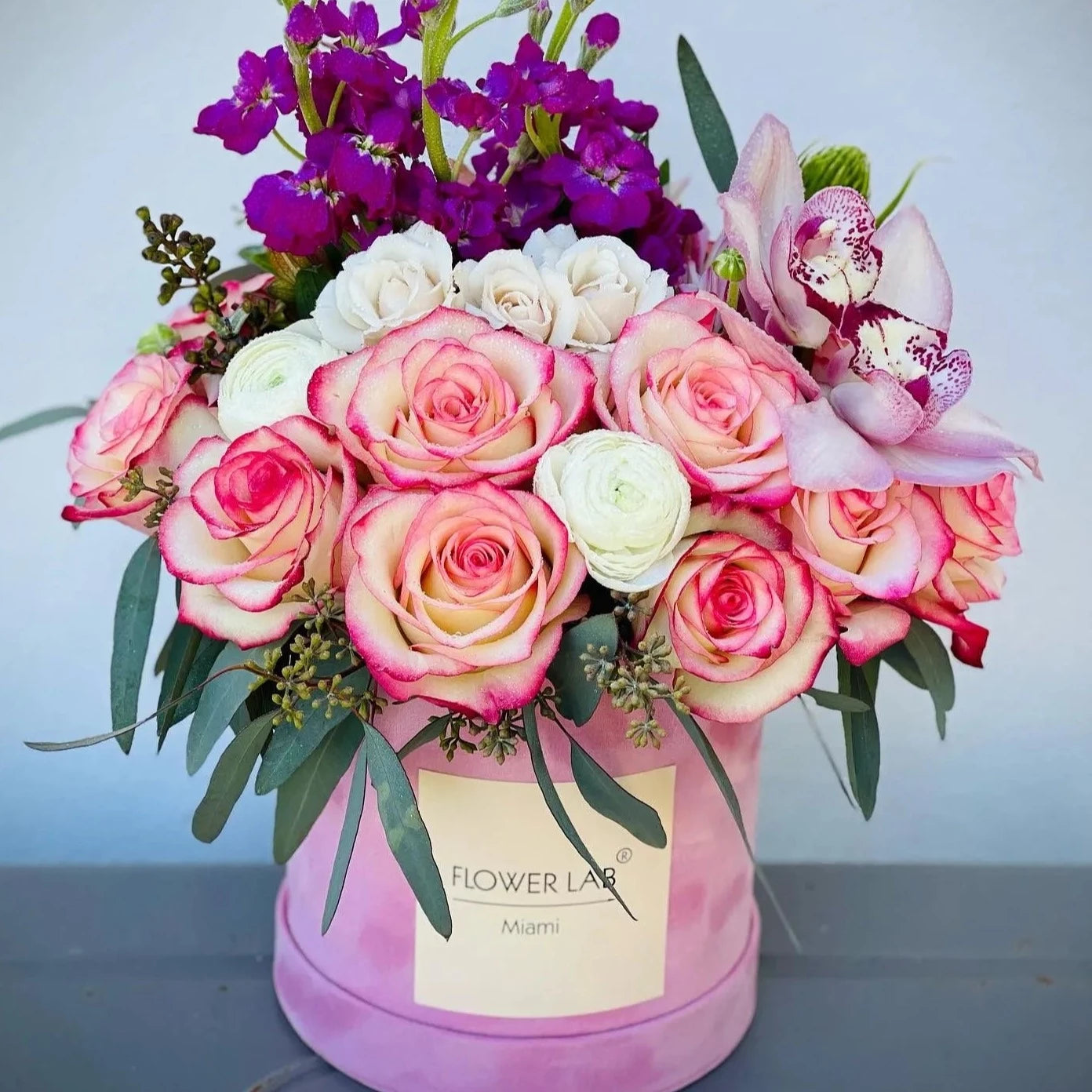 Perfecto Arrangement with Bicolor Roses Mini Roses, Cymbidium Orchids, Stock, Eucalyptus