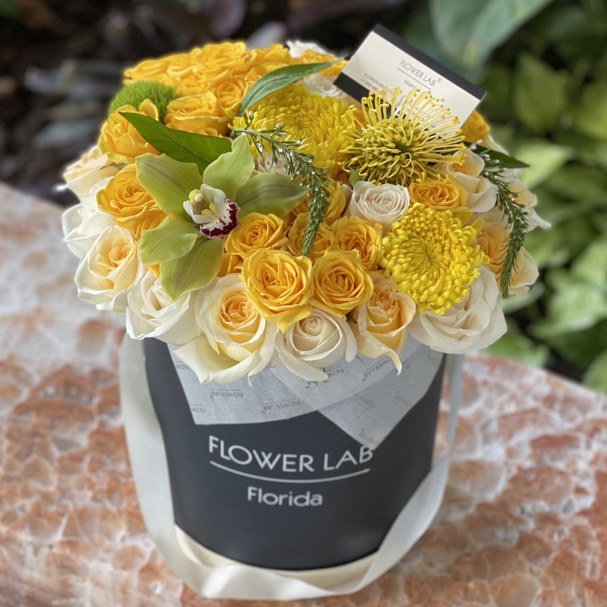 white and yellow roses, cymbidium, greens