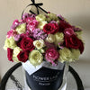 pink, green, red roses in a hatbox
