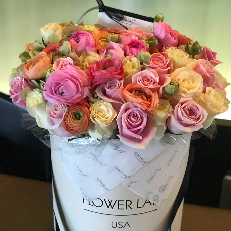 ranunculuses, roses in a hatbox